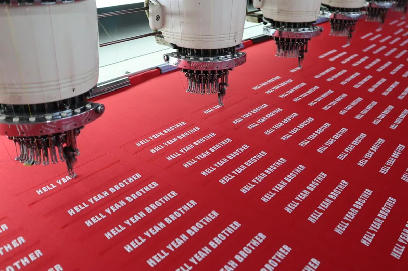 Embroidery needles stitching a run of patches on the cloth