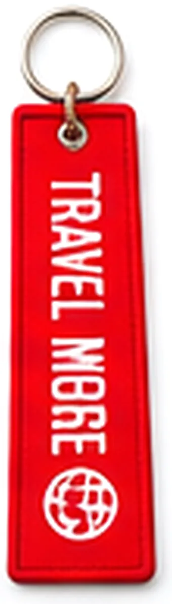 Red flight tag keychain reading Travel More