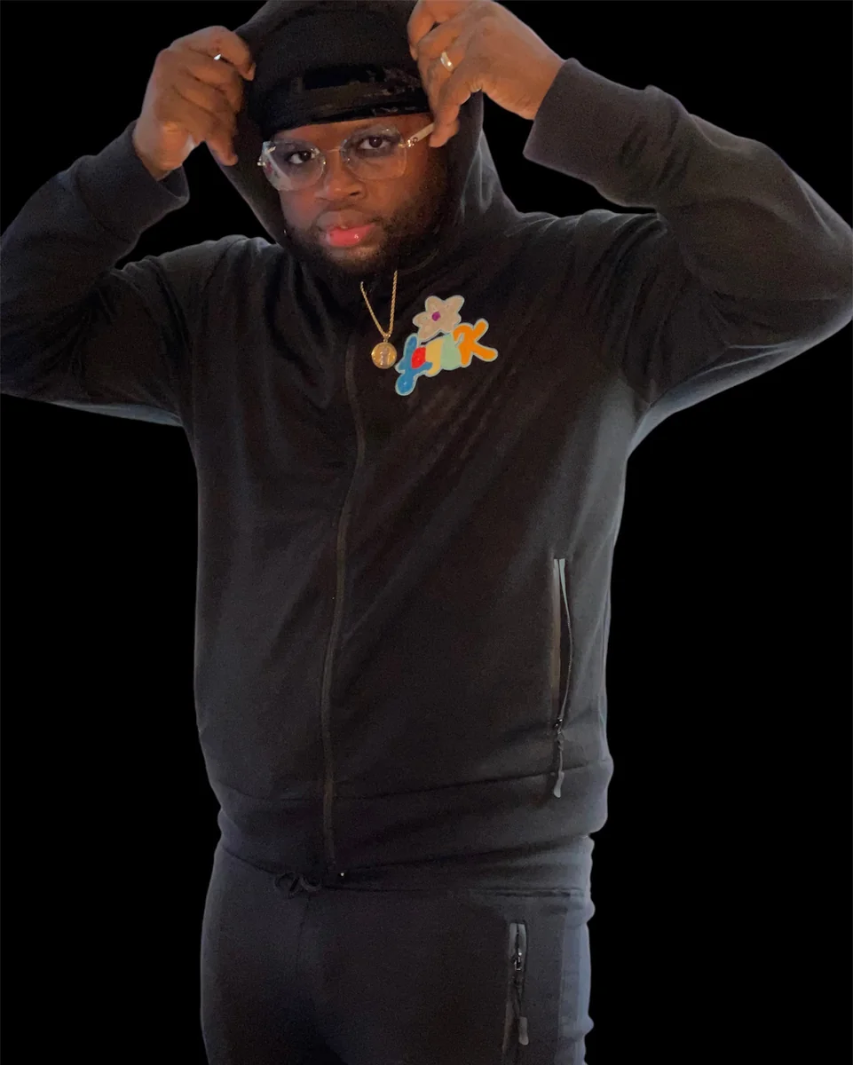 Streetwear black zip hoodie with custom chest patch worn by model