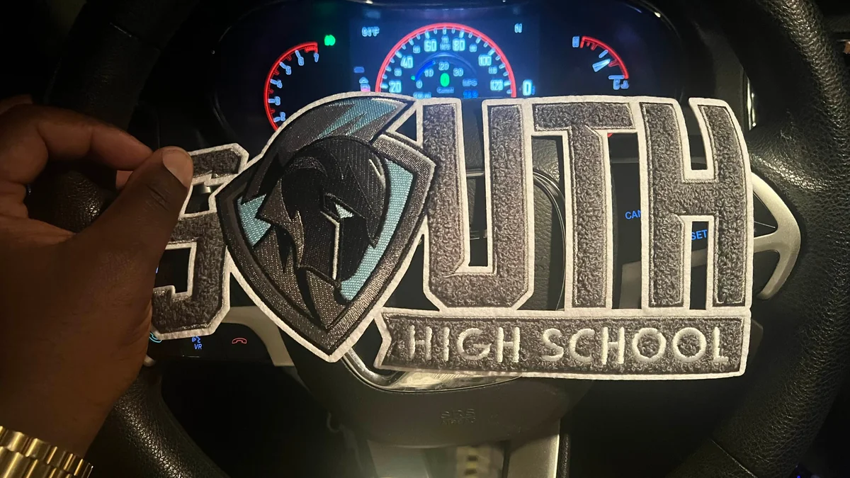Giant letter patch SOUTH HIGH SCHOOL held in hands showing real scale