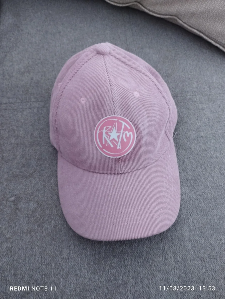 Real factory production sample: circular embroidered crest sewn onto pink corduroy curved baseball cap